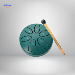 Green steel tongue drum with numbered scale markers and beater.