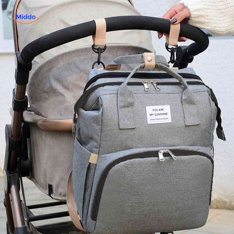 Diaper backpack with stroller attachment hooks for convenient hands-free carrying.