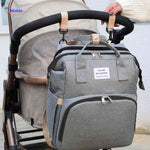 Diaper backpack with stroller attachment hooks for convenient hands-free carrying.
