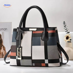 Styled tote bag with decorative pom-pom and supportive shoulder straps.