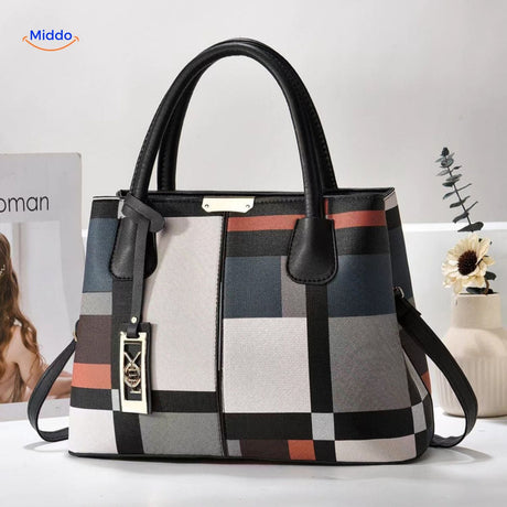 Styled tote bag with decorative pom-pom and supportive shoulder straps.
