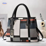 Styled tote bag with decorative pom-pom and supportive shoulder straps.