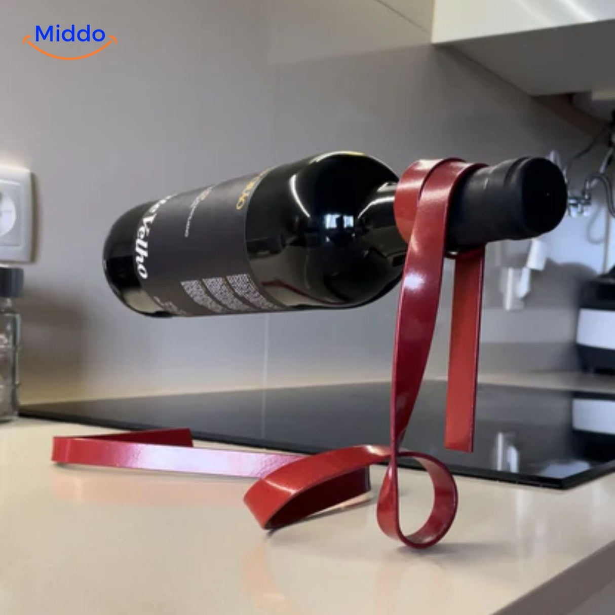 Elegant suspended wine holder with golden ribbon detail.
