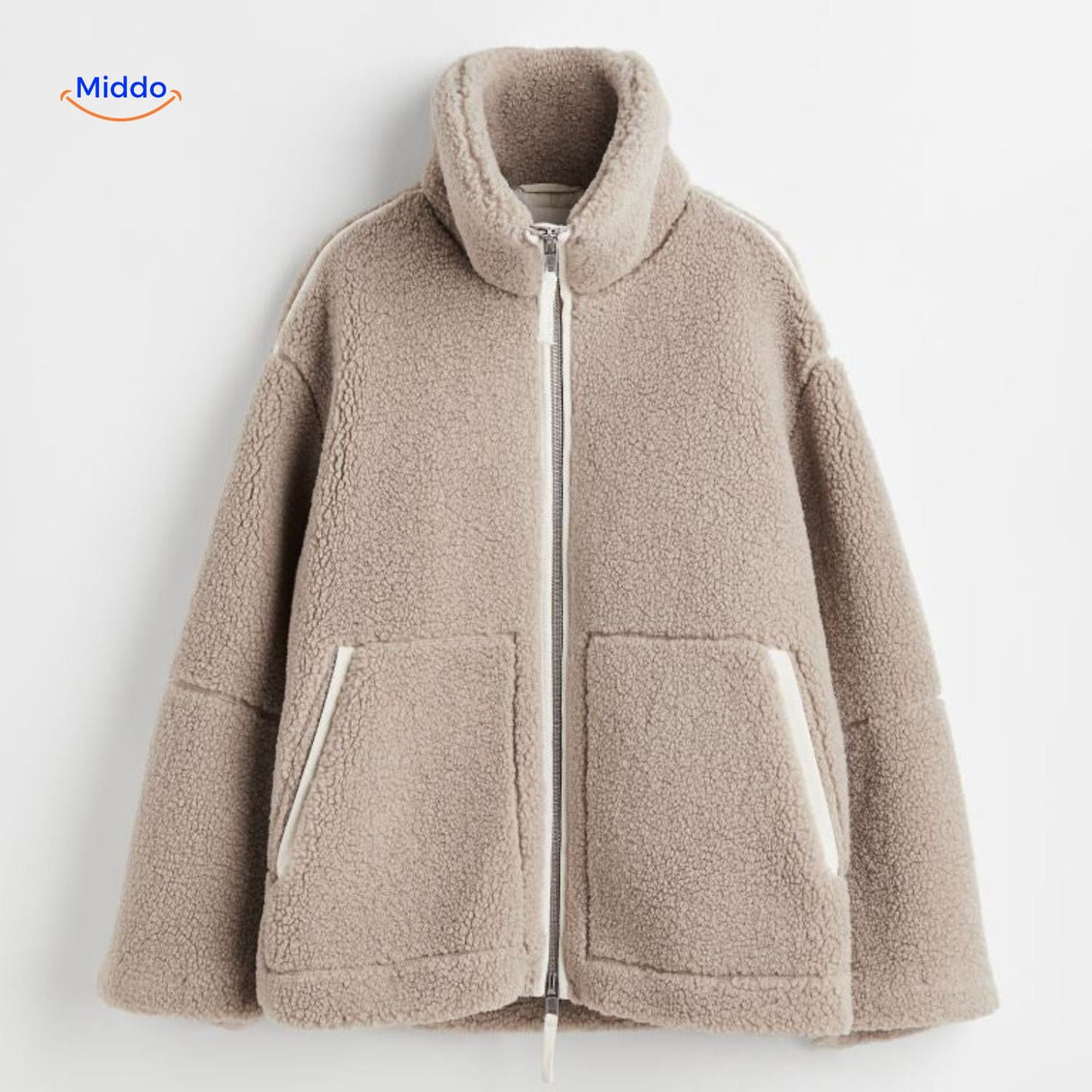 Beige teddy wool coat fabric closeup highlighting soft texture and construction.