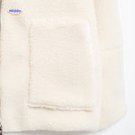 White teddy wool coat upper zipper detail showing collar and neck construction.