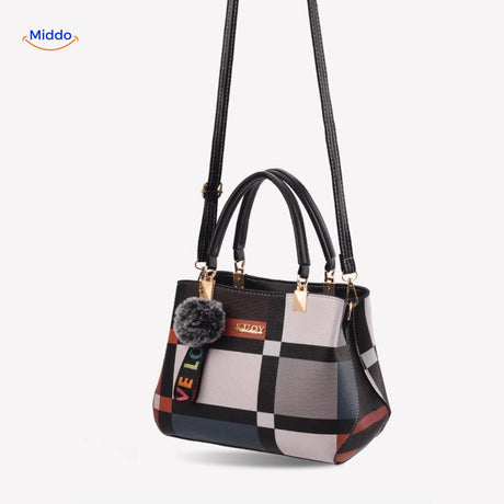 Trendy shoulder tote with symmetrical pattern and stylish pom-pom.