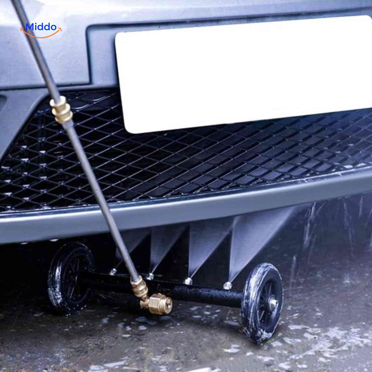 High-pressure undercarriage cleaner spraying water jet on clean ground surface.