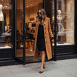 Woman wearing elegant button-front Veloura coat leaving boutique store.