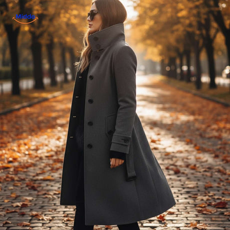 Grey button-front Veloura coat styled among autumn foliage.