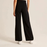 Black wide-leg trousers showing relaxed fit and polished tailored appearance.