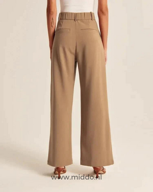Back view of wide-leg trousers highlighting structural seams and relaxed fit.