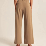 Back view of wide-leg trousers highlighting structural seams and relaxed fit.