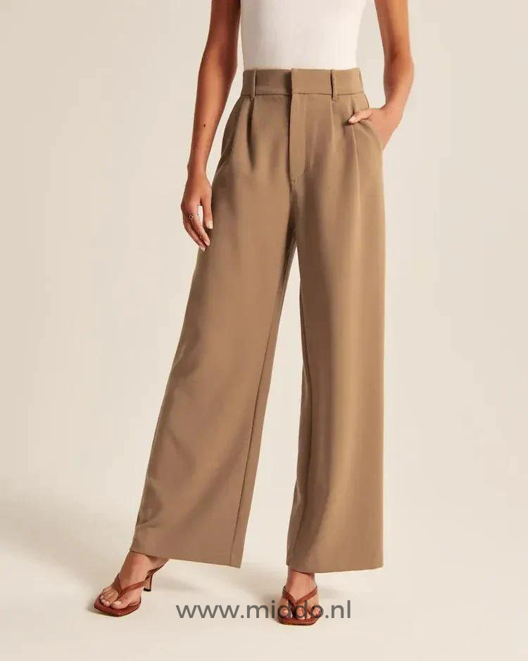 Women's wide-leg trousers in warm brown showing flattering drape and tailored details.