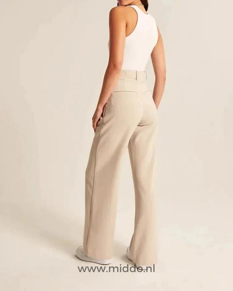 Cream-colored wide-leg trousers worn with effortless styling for all-day comfort.
