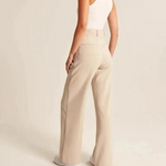 Cream-colored wide-leg trousers worn with effortless styling for all-day comfort.