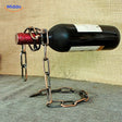 Suspended wine bottle holder with rose gold chain.