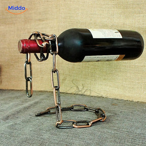 Suspended wine bottle holder with rose gold chain.