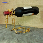 Wine bottle holder featuring elegant gold chain suspension.