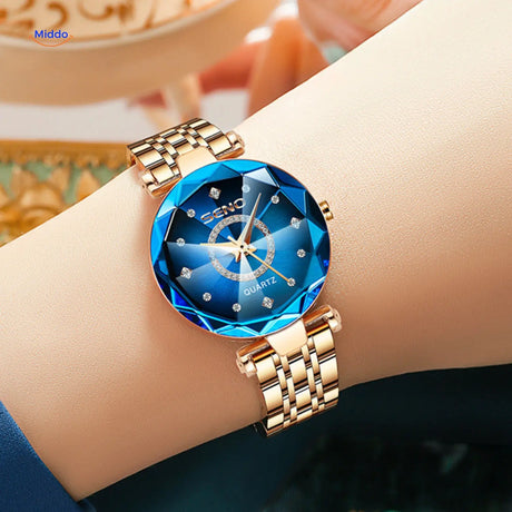 Women's stainless steel quartz watch with gold case and glass dial face, front product view.
