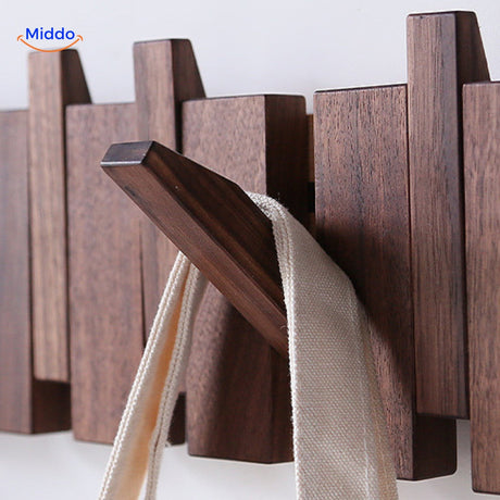 Close-up detail of handmade wooden piano coat rack's foldable hook mechanism.