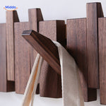Close-up detail of handmade wooden piano coat rack's foldable hook mechanism.