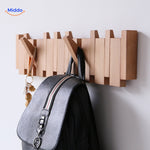 Handmade wooden piano coat rack with coats and bags organized on foldable hooks.